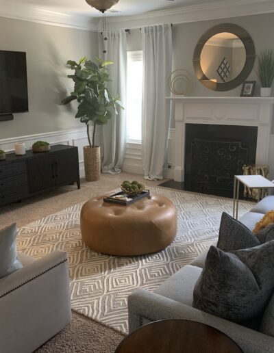 A cozy living room with a sectional sofa, television, and a decorative fireplace.